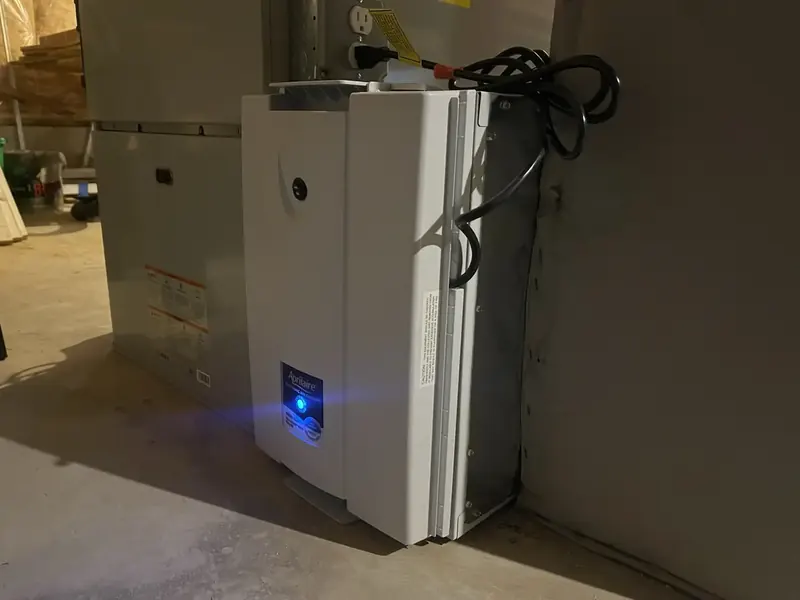 Aprilaire whole-home air cleaner installed beside a Bosch unit in a Southern NH basement by A.J. LeBlanc Heating