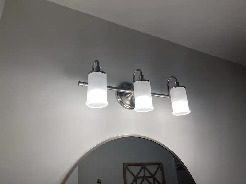 Three-light brushed-nickel bathroom vanity fixture installation by A.J. LeBlanc Heating in Southern NH