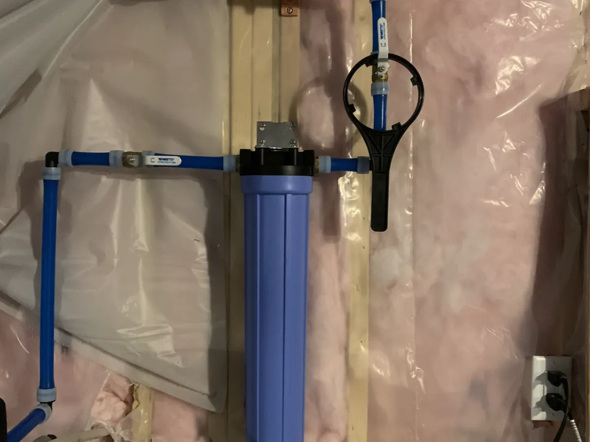 Whole-house blue pre-filter housing with PEX plumbing and filter wrench installed by A.J. LeBlanc Heating on a Southern NH city water line