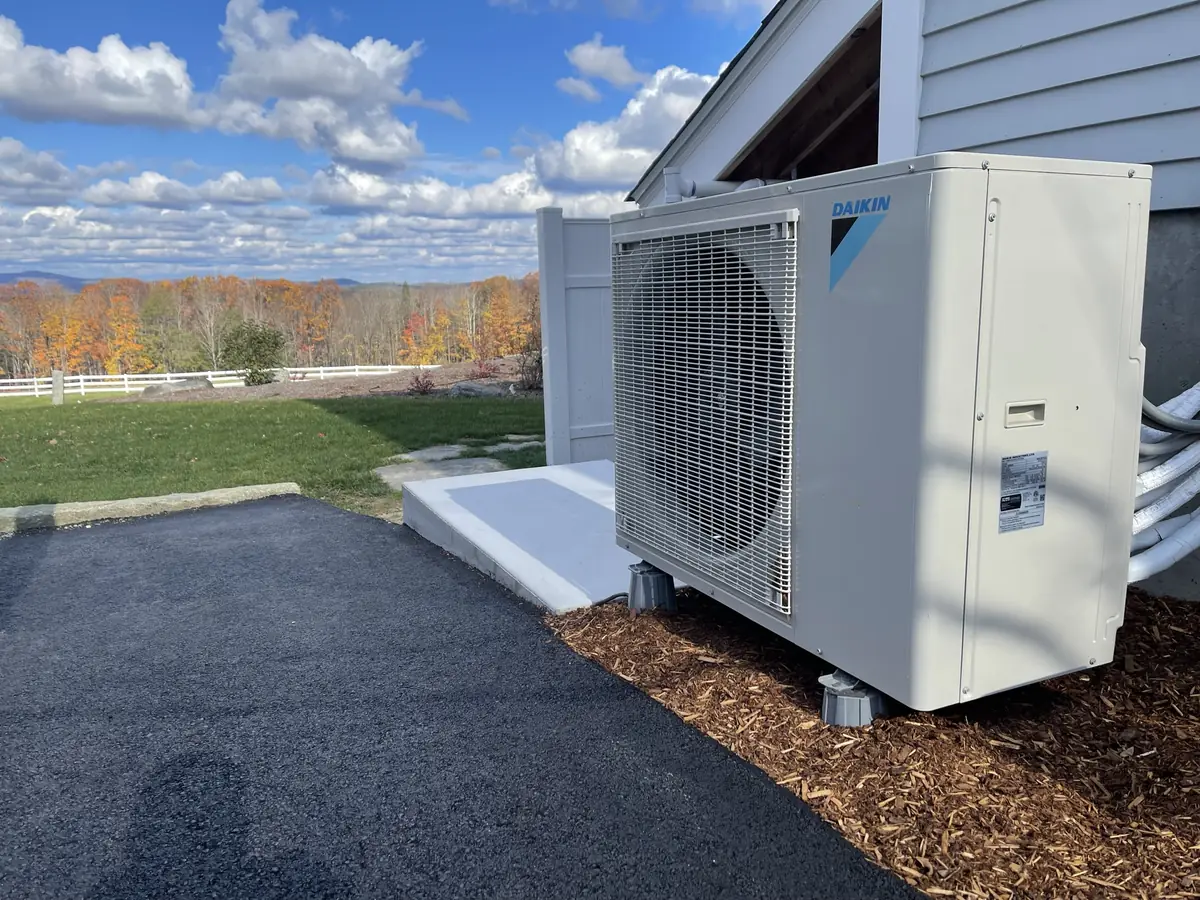 Daikin ductless mini split heat pump outdoor unit installation in Southern NH with autumn mountain views