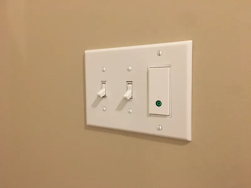 Decora smart light switch with LED indicator installed alongside standard toggle switches in a Southern NH home by A.J. LeBlanc Heating