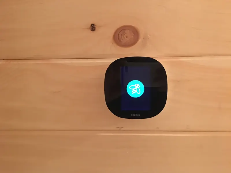 Ecobee smart thermostat installed on a pine plank wall by A.J. LeBlanc Heating in a Southern NH home