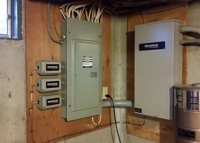 Interior basement install showing three Generac SmartSwitch load shedding modules wired alongside a Generac automatic transfer switch and main panel in a Southern NH home, by A.J. LeBlanc Heating