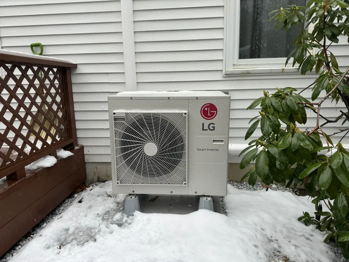 LG outdoor ductless mini split heat pump installed in winter against a Southern NH home