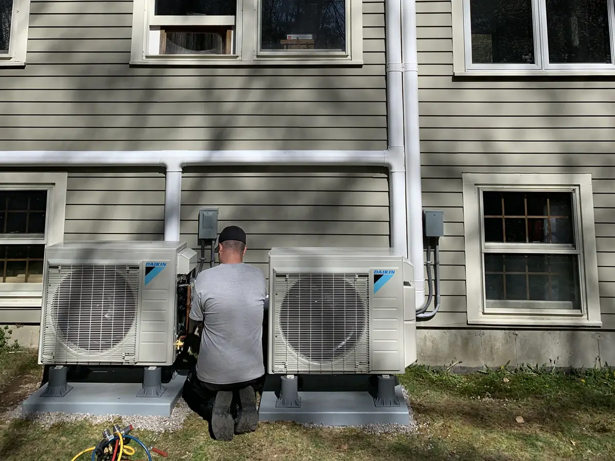 A.J. LeBlanc Heating technician installing a multi-zone Daikin outdoor mini split system at a Southern NH home