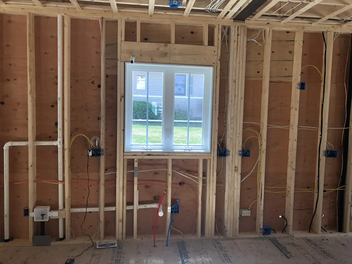 New-construction plumbing rough-in with PEX water lines and PVC drain stubs framed into stud walls by A.J. LeBlanc Heating in Southern NH