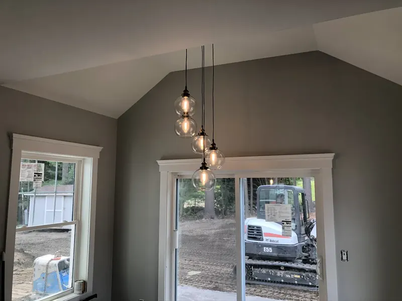 Five-globe Edison-style pendant cluster installation over a kitchen island in a Southern NH home by A.J. LeBlanc Heating